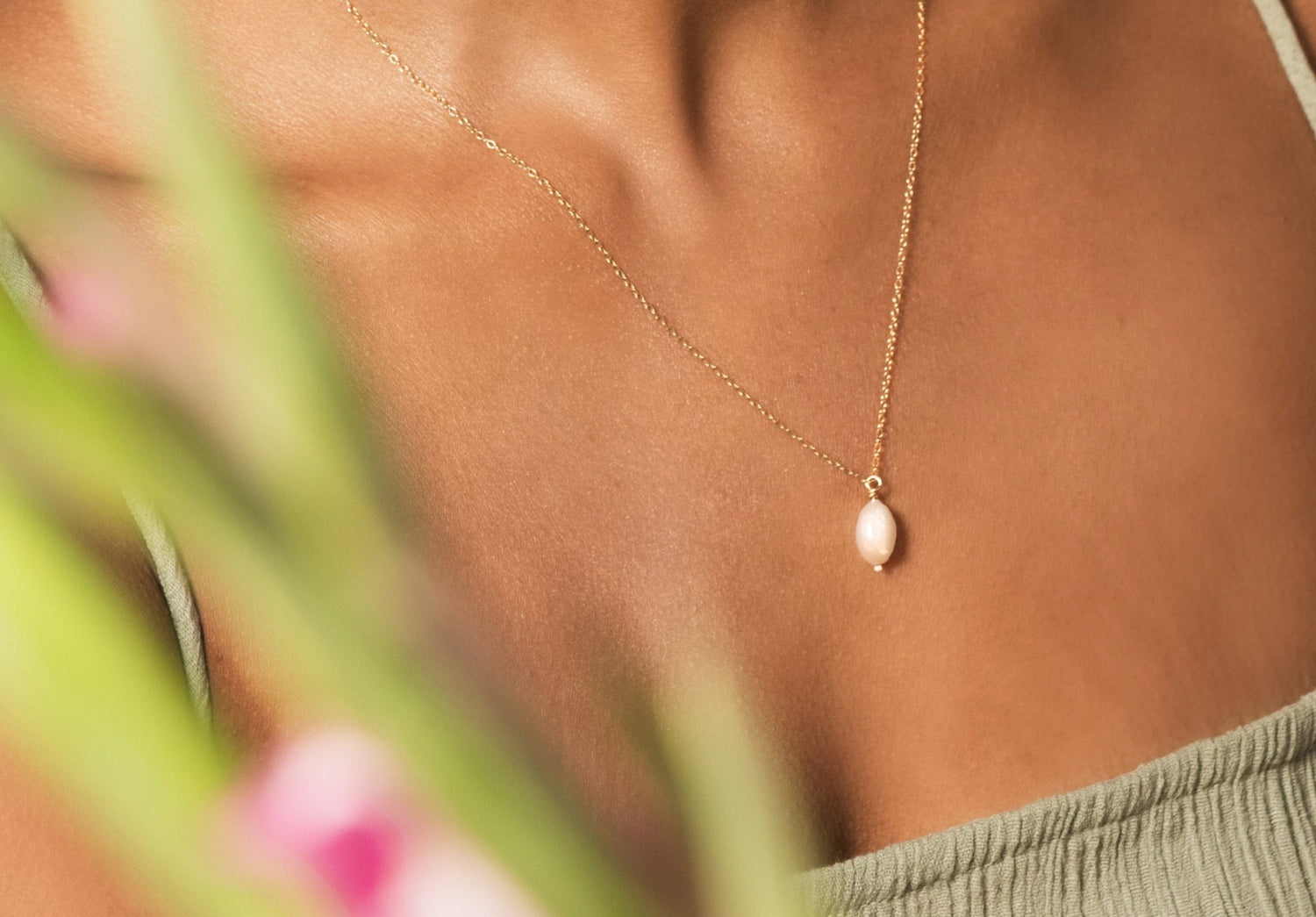 model wearing gold pearl necklace and pearl hoop earrings
