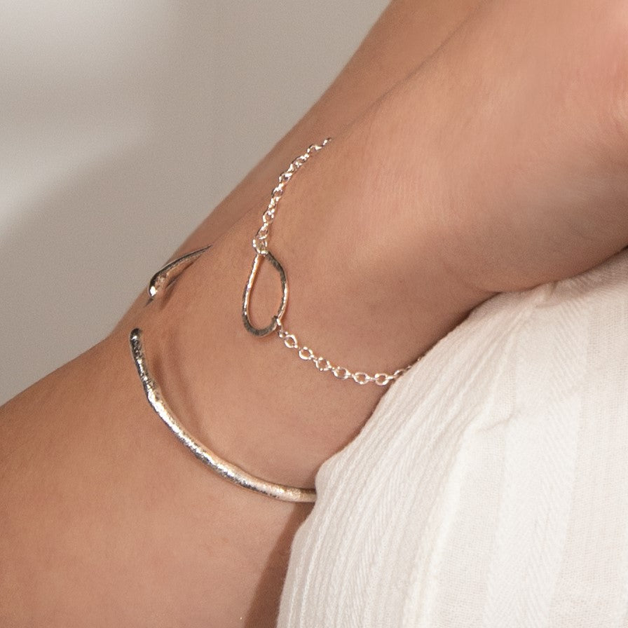 molten cuff bracelet worn alongside teardrop bracelet