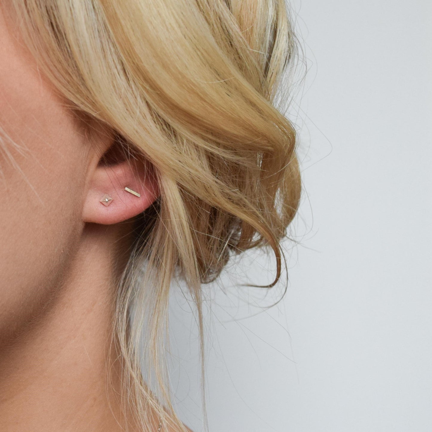 blond model wearing pyramid studs alongside bar studs