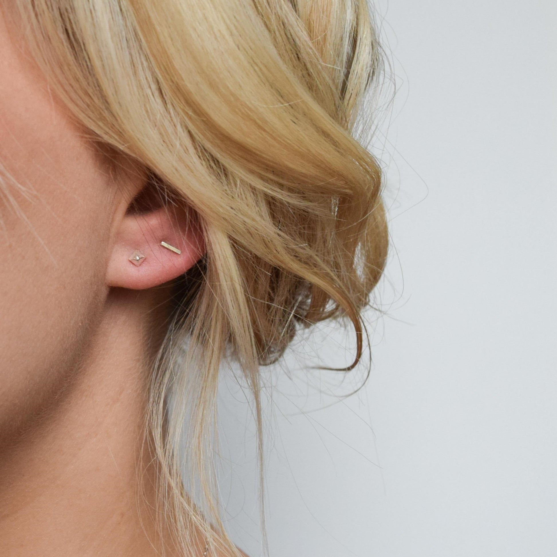blond model wearing pyramid studs alongside bar studs