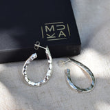Image of carvel oval hoop earrings in silver sitting next to MUKA gift box