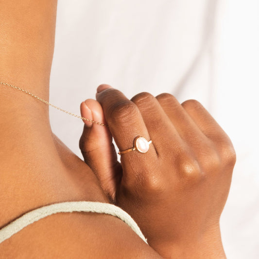 model wears gold pearl hoops and gold pearl ring, camera view is from the back