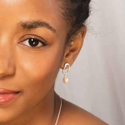 Model wearing pearl earrings, necklace and ring