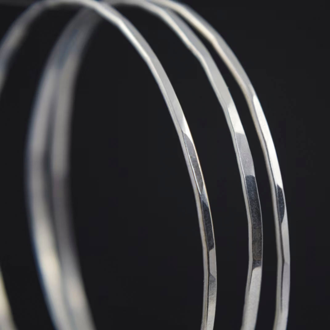Slim bangles created in recycled sterling silver with a hammered finish