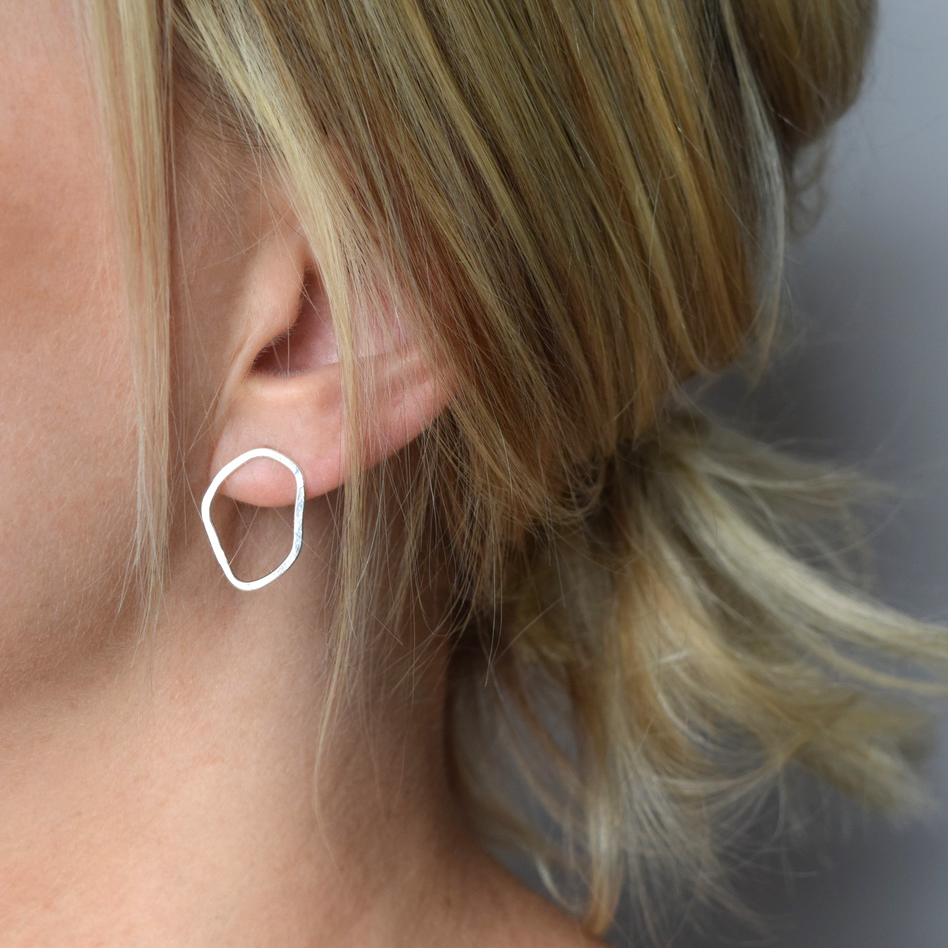 Model wearing organic shape earrings in silver