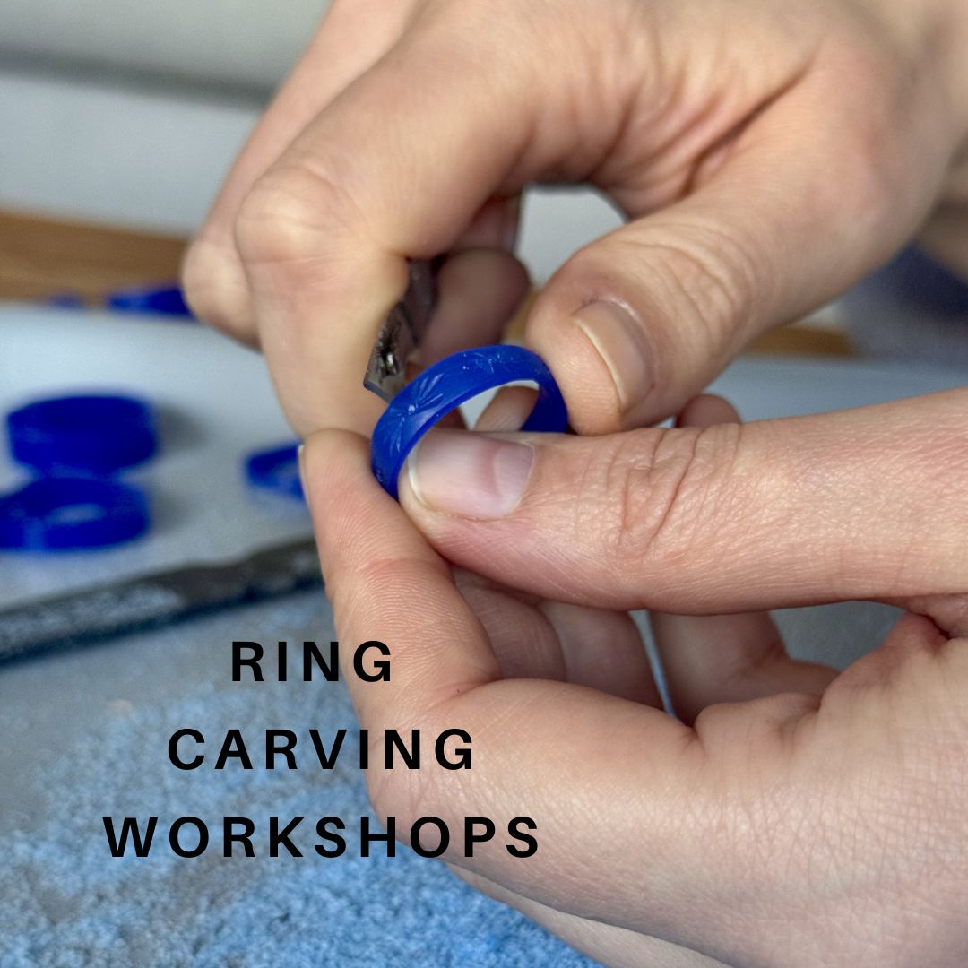 Close-up of a person's hands carving a ring in wax which will be cast in silver, with the text 'RING CARVING WORKSHOPS' overlaid on the image.