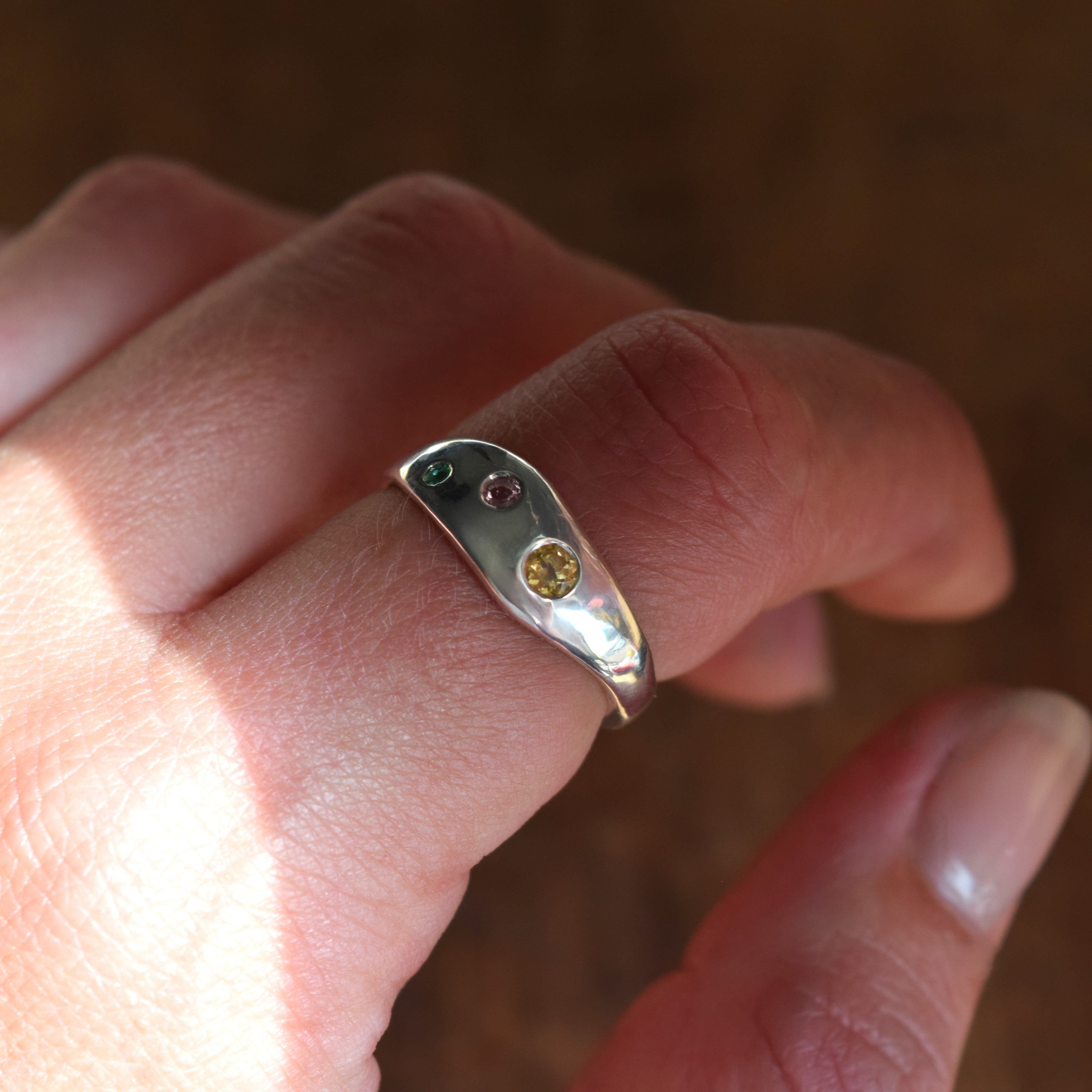 Recycled silver wave ring with citrine, pink sapphire and emerald stones set into the silver band. Colorful and fun ring handmade in UK