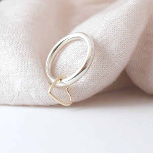 Heart spinner ring leaning against pale pink fabric