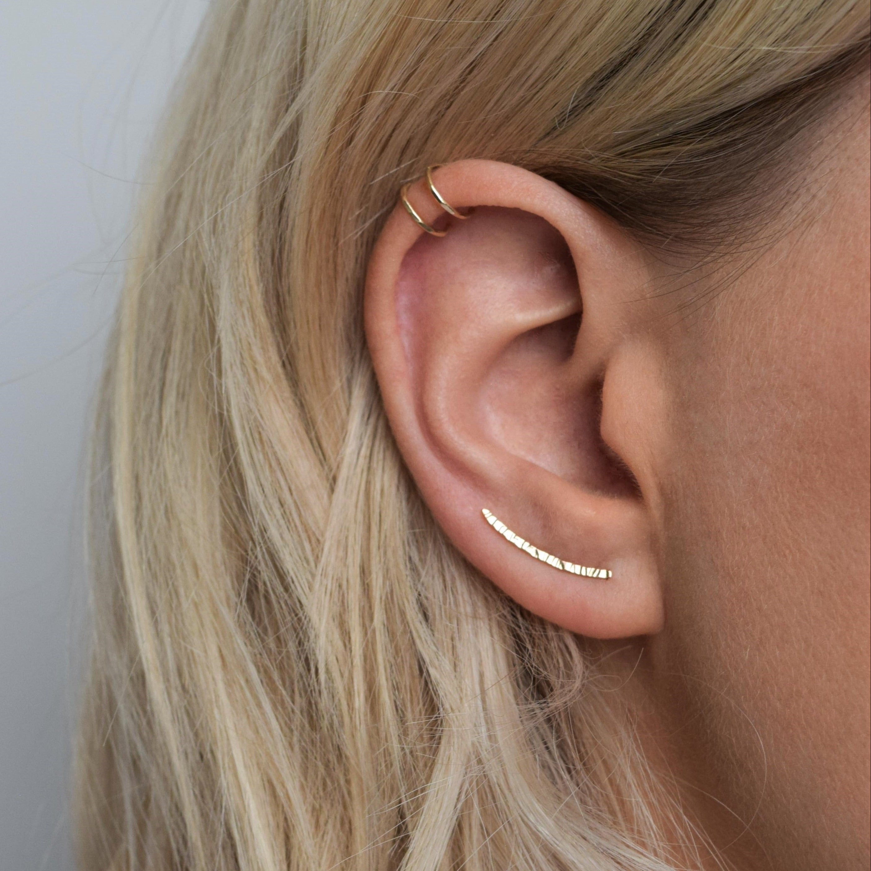hammered gold ear climber worn with double helix cuff in gold