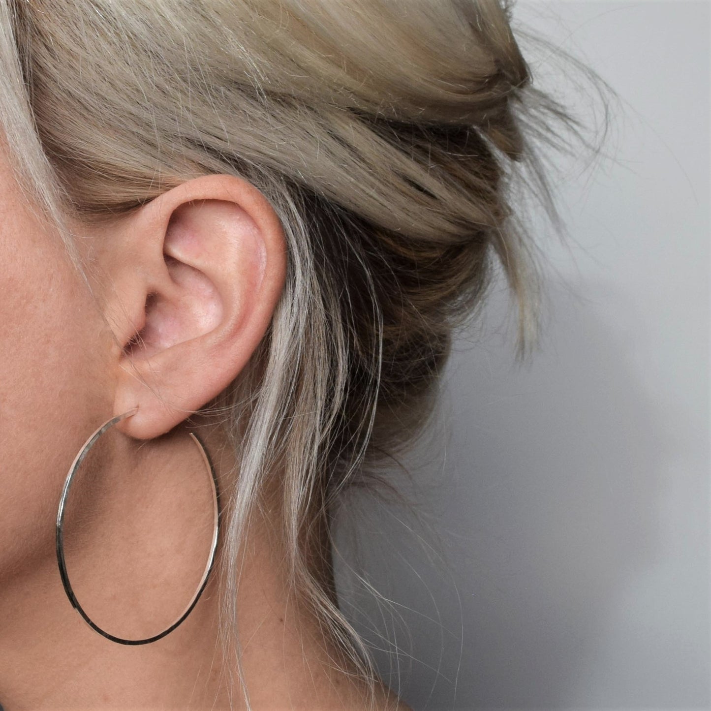 Large silver hoops earrings on blond model