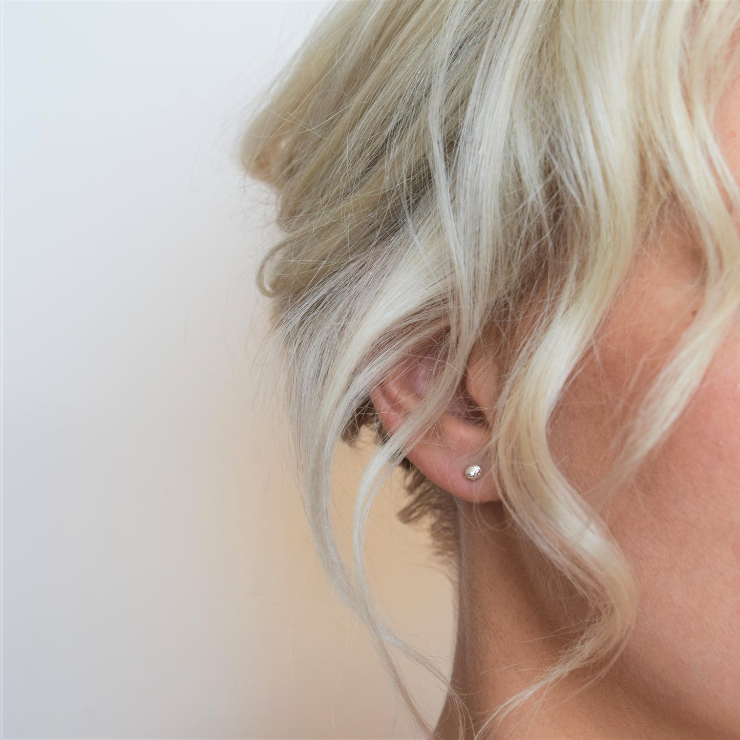 image of silver ball stud earrings on model