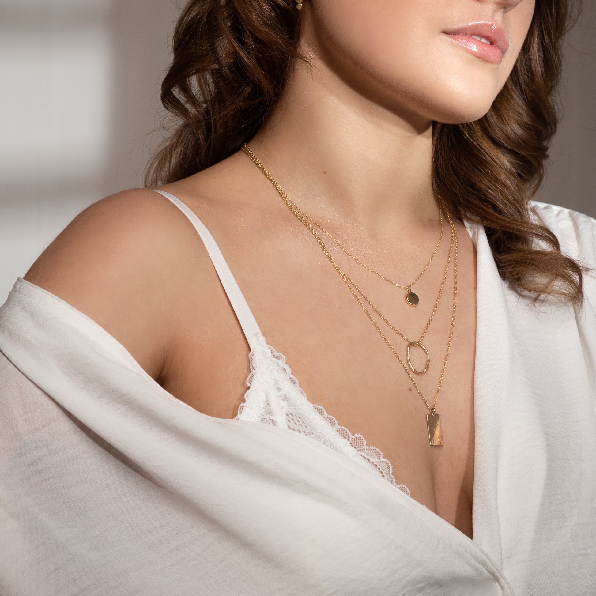 MUKA studio gold dot necklace layered with molten oval necklace and personalised initial necklace