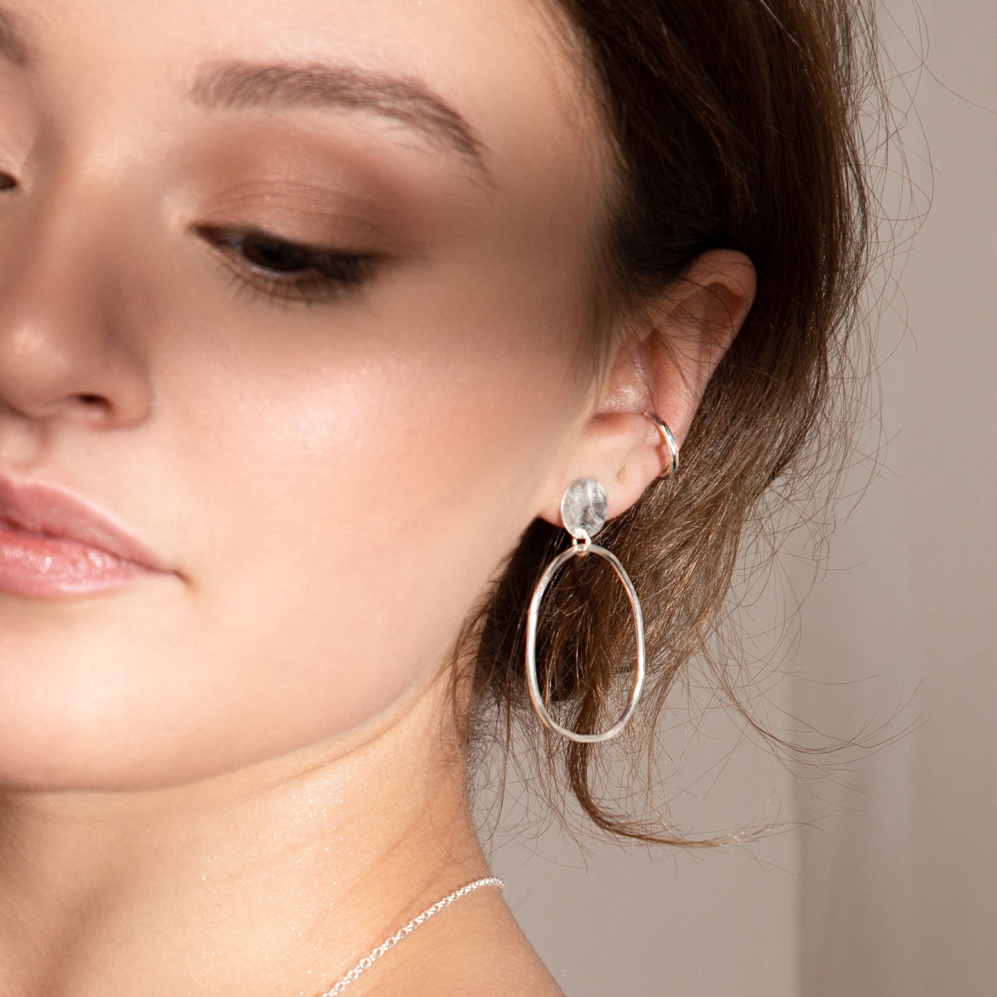 model wears clara drop earrings along with wide molten band