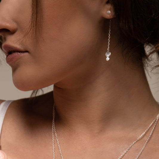 Model wears Ella triple dot drop earrings in silver