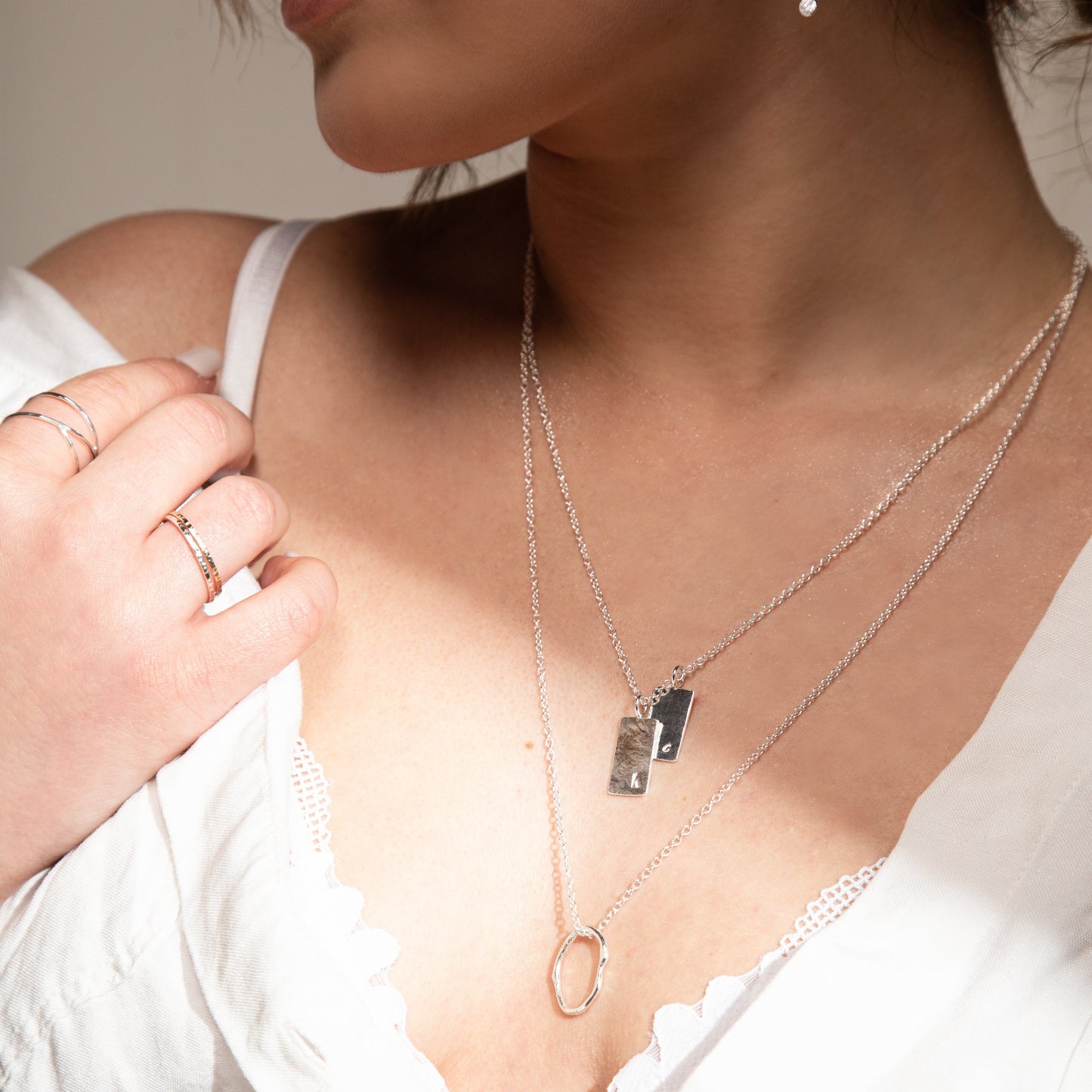 Personalised squre necklaces on model with molten oval necklace