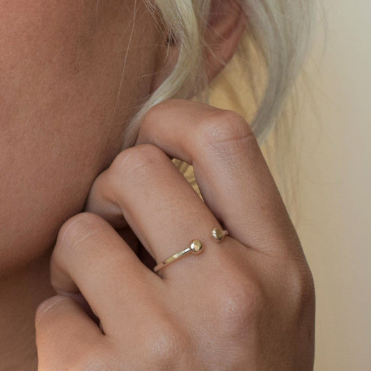 MUKA studio gold dot ring worn on middle finger by blond model