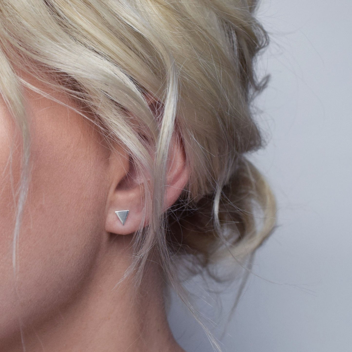 Solid tringle stud worn by blond model