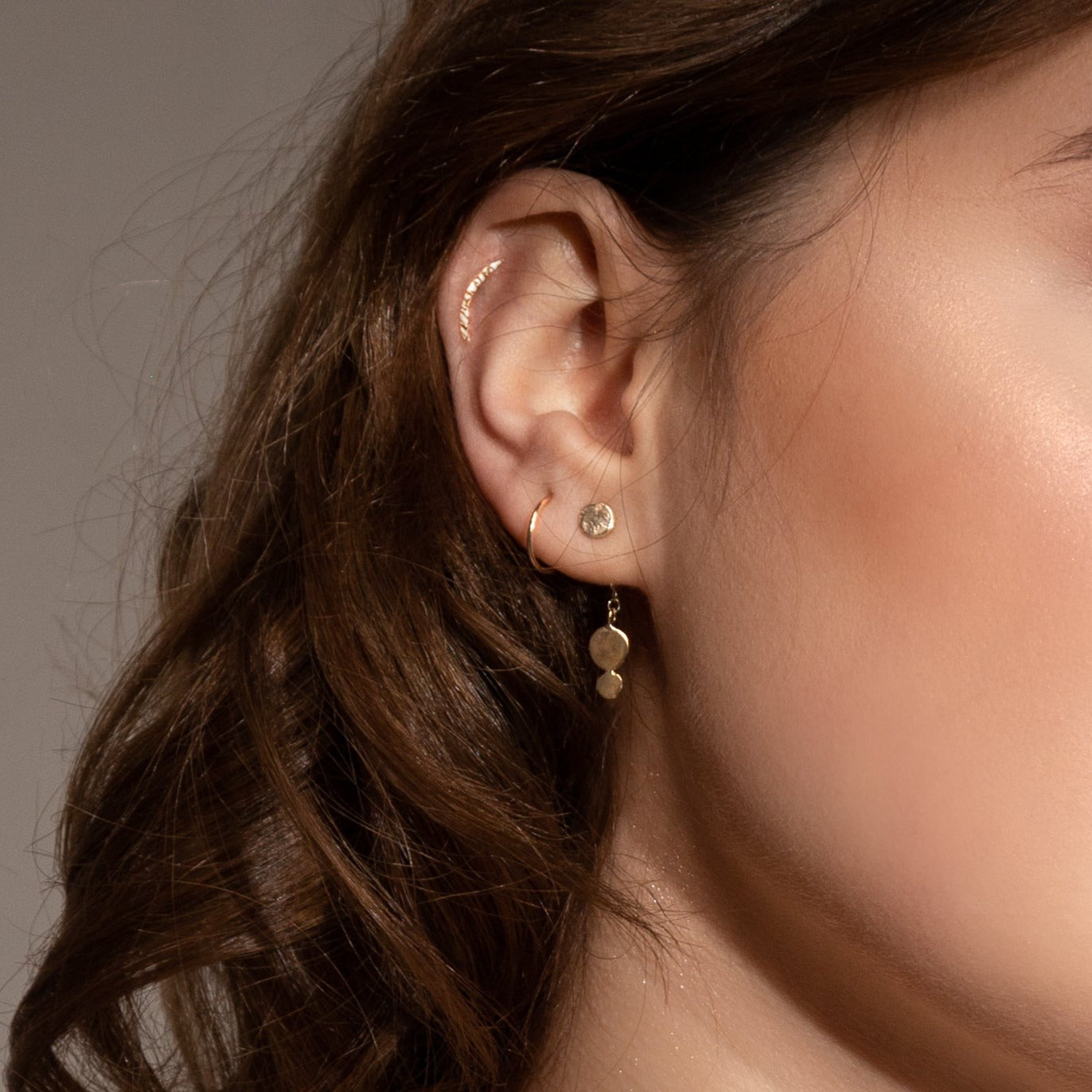 recycled 9ct gold sleeper hoop worn by model in second lobe piercing