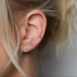 images shows silver teardrop stud  worn next to silver bar stud and silver conch cuff
