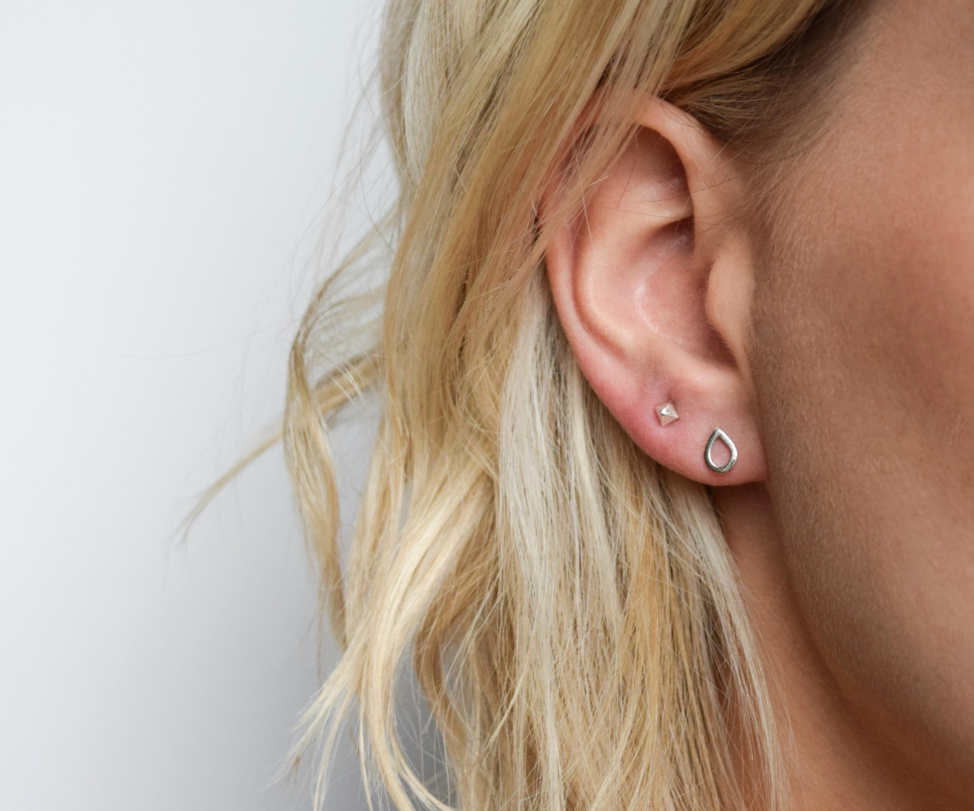 pyramid studs worn in the second piercing hole and teardrops studs in the first. Handmade in Glasgow, UK using recycled silver and gold