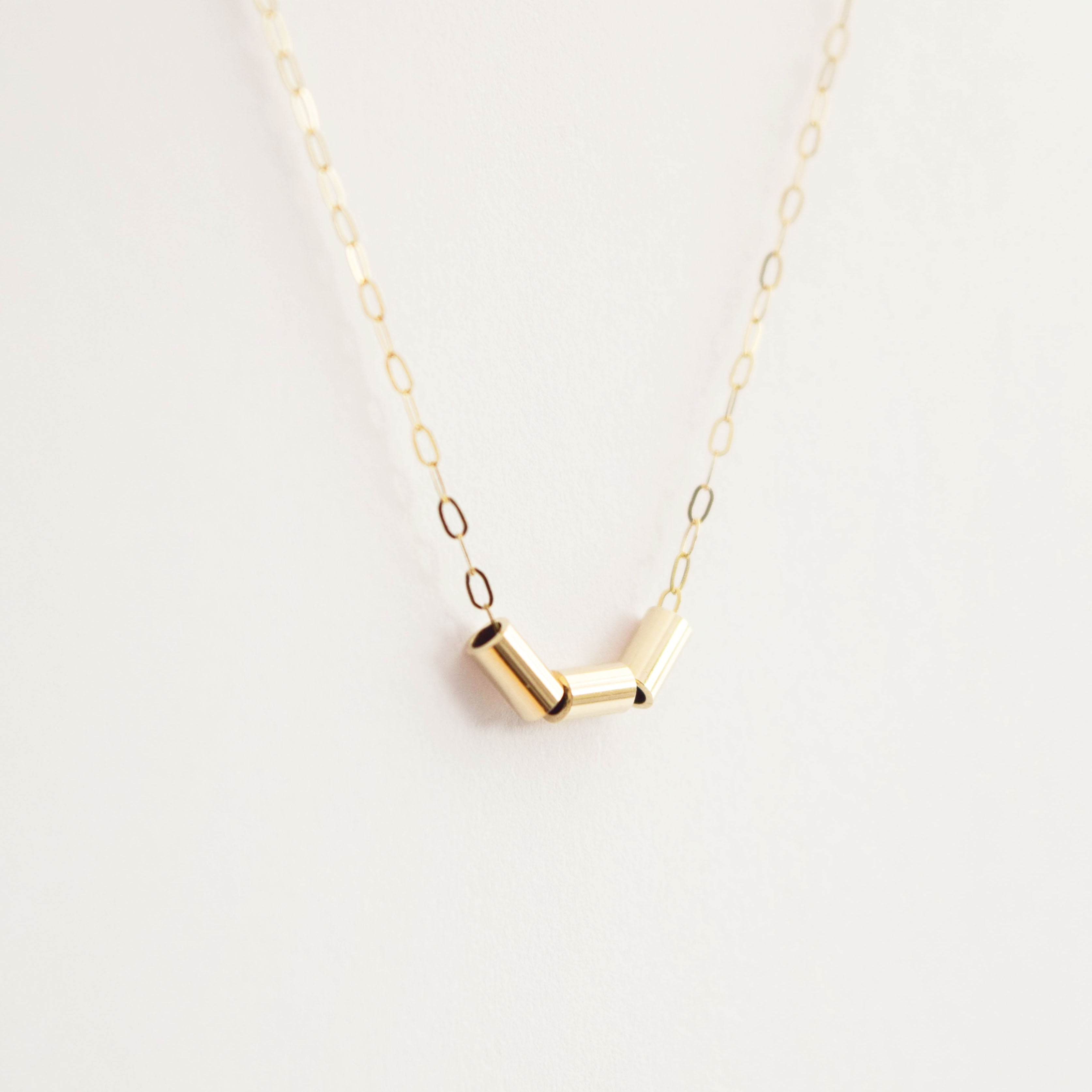 MUKA studio gold nugget necklace hanging on white background