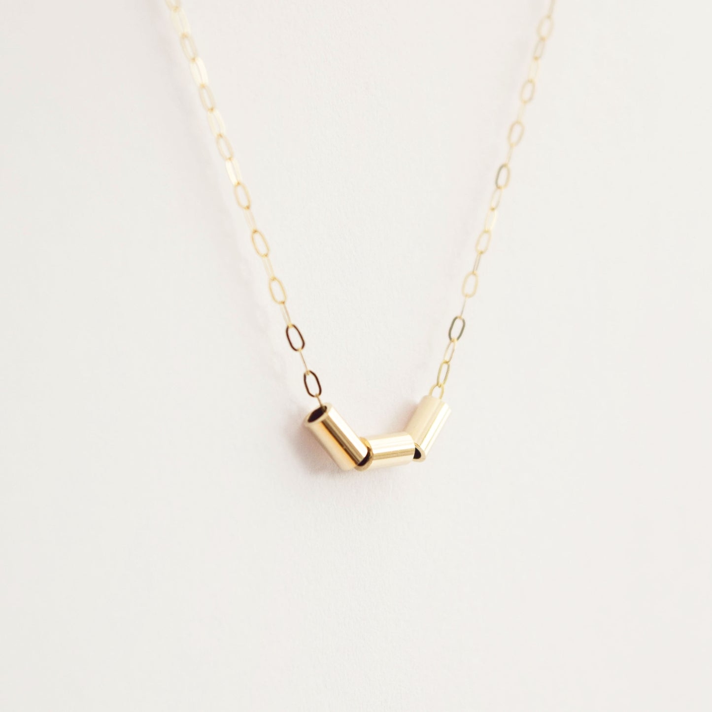 MUKA studio gold nugget necklace hanging on white background