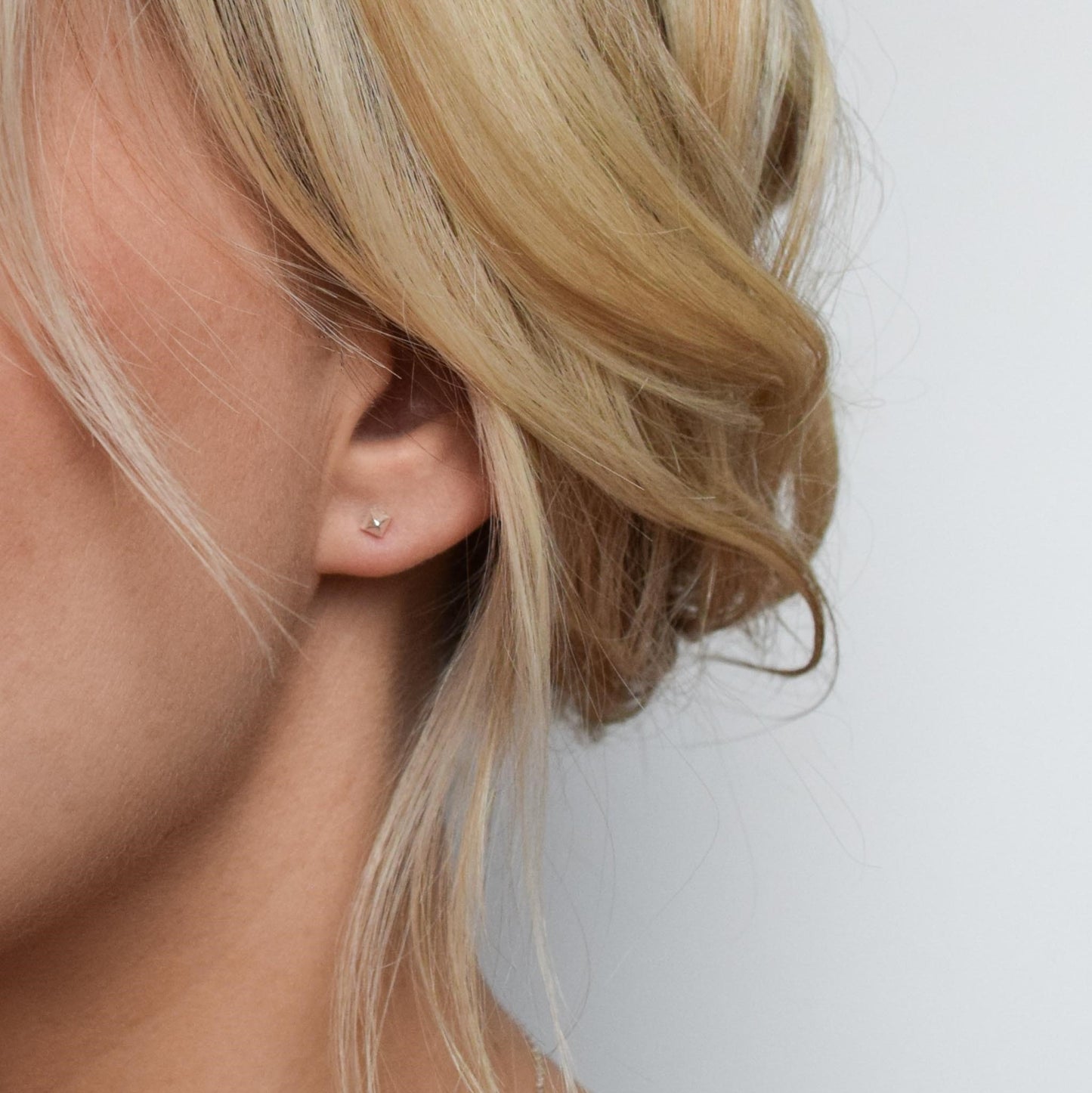 Pyramid stud earrings on blond model