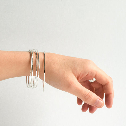 five stacking bangles hanging on a wrist